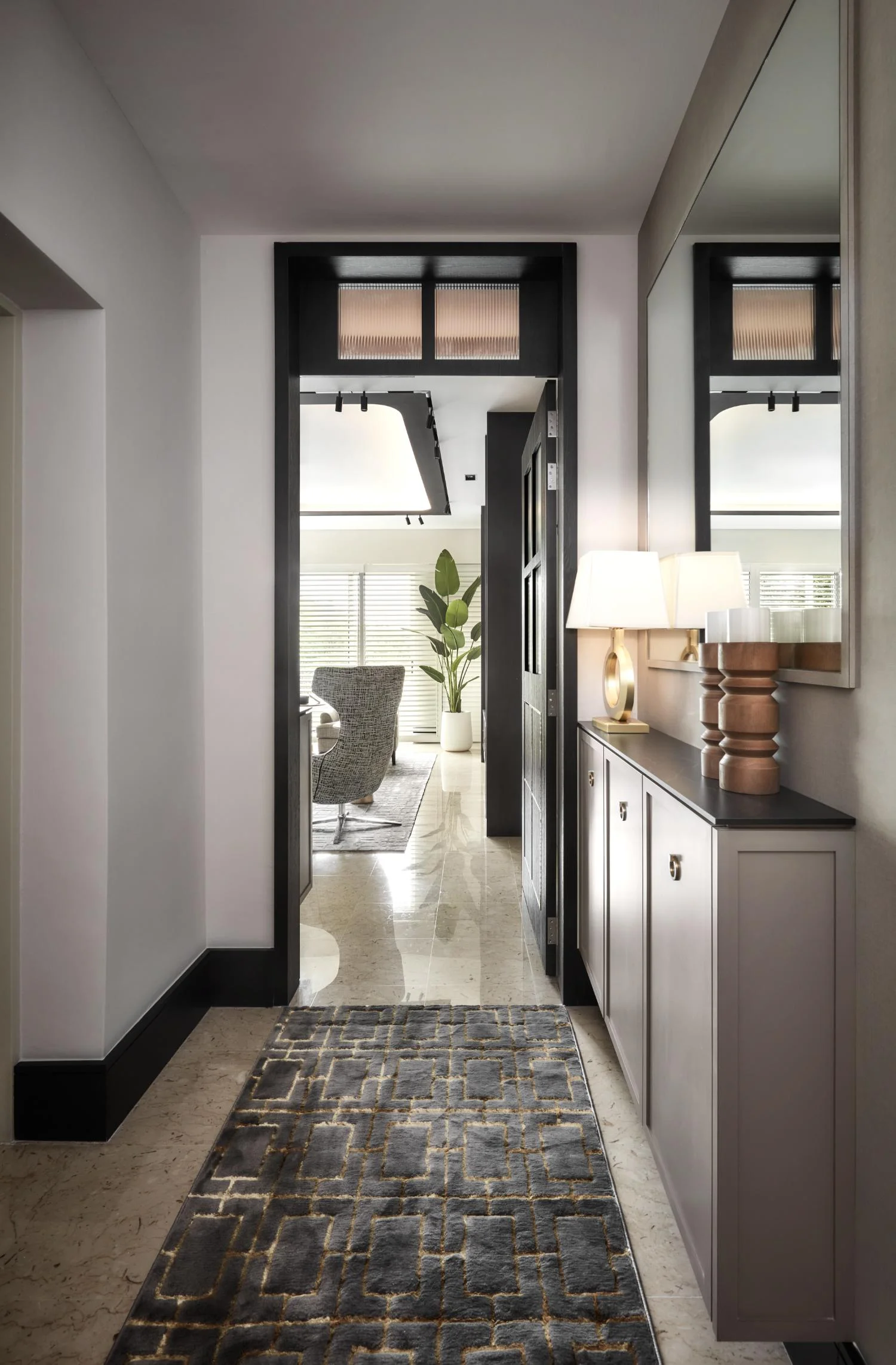 Private lift lobby — stone-effect feature wall, warm cove lighting, and considered arrival moment
